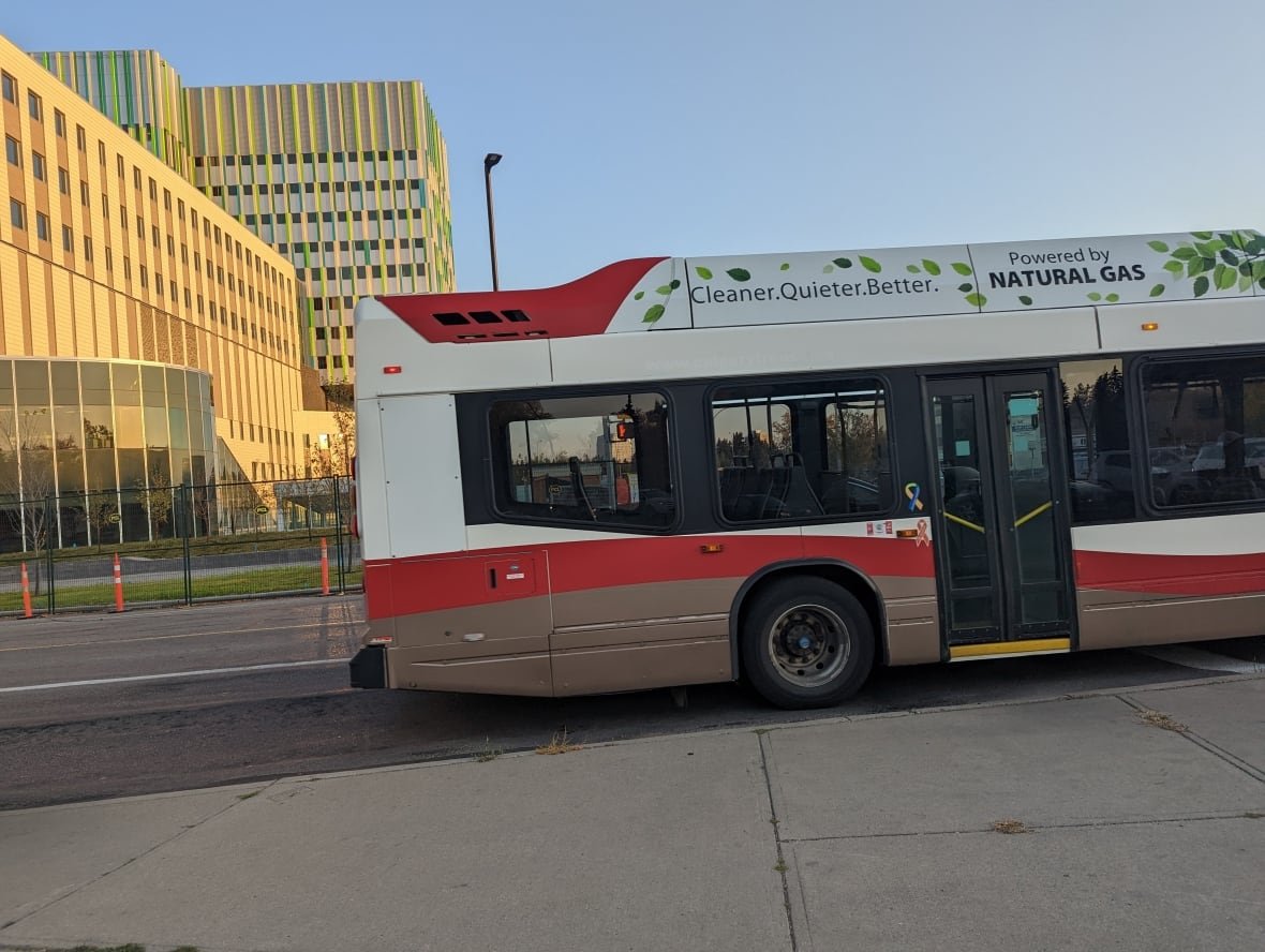 calgary-transit-natural-gas-bus Red and white bus with words "Cleaner. Quiter. Better. Powered by natural gas" on it.