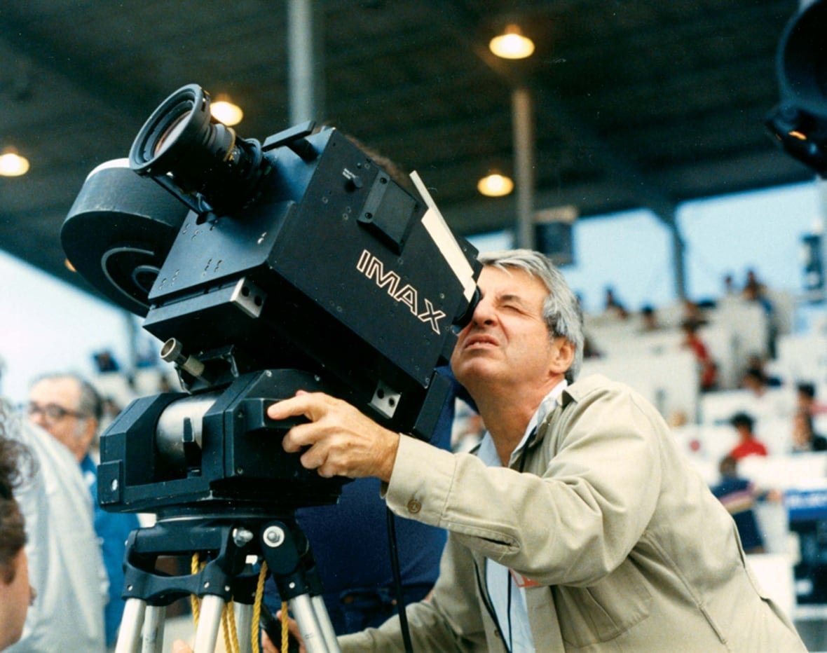 graeme-ferguson A man with grey hair looks through the viewfinder of an Imax camera pointed up at the sky.