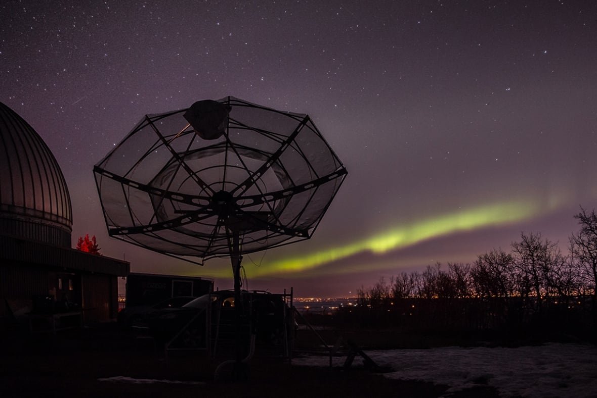 rothney-astrophysical-observatory A radio telescope is silhouetted against the northern lights.