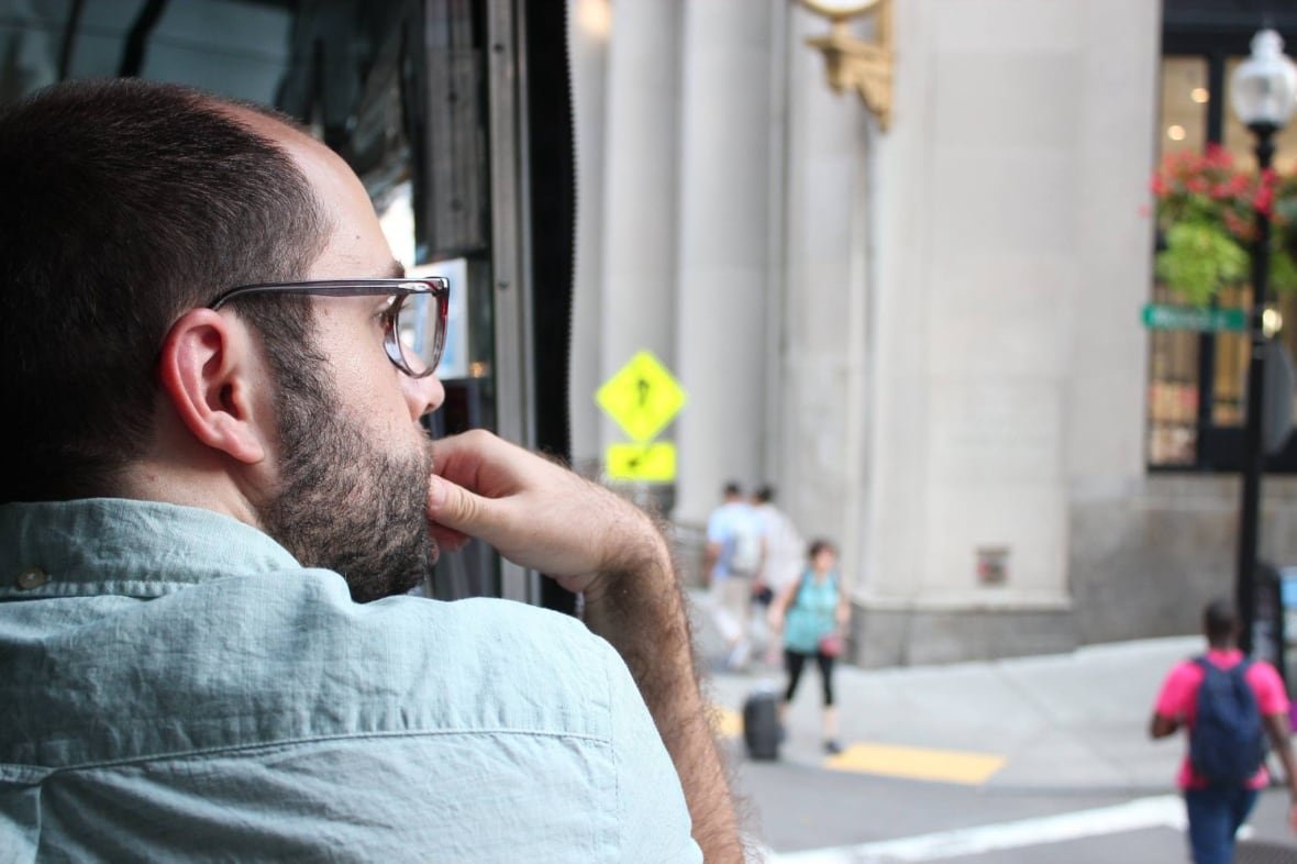 sam-dunsiger-from-behind A man with a beard is photographed, pensively from behind.