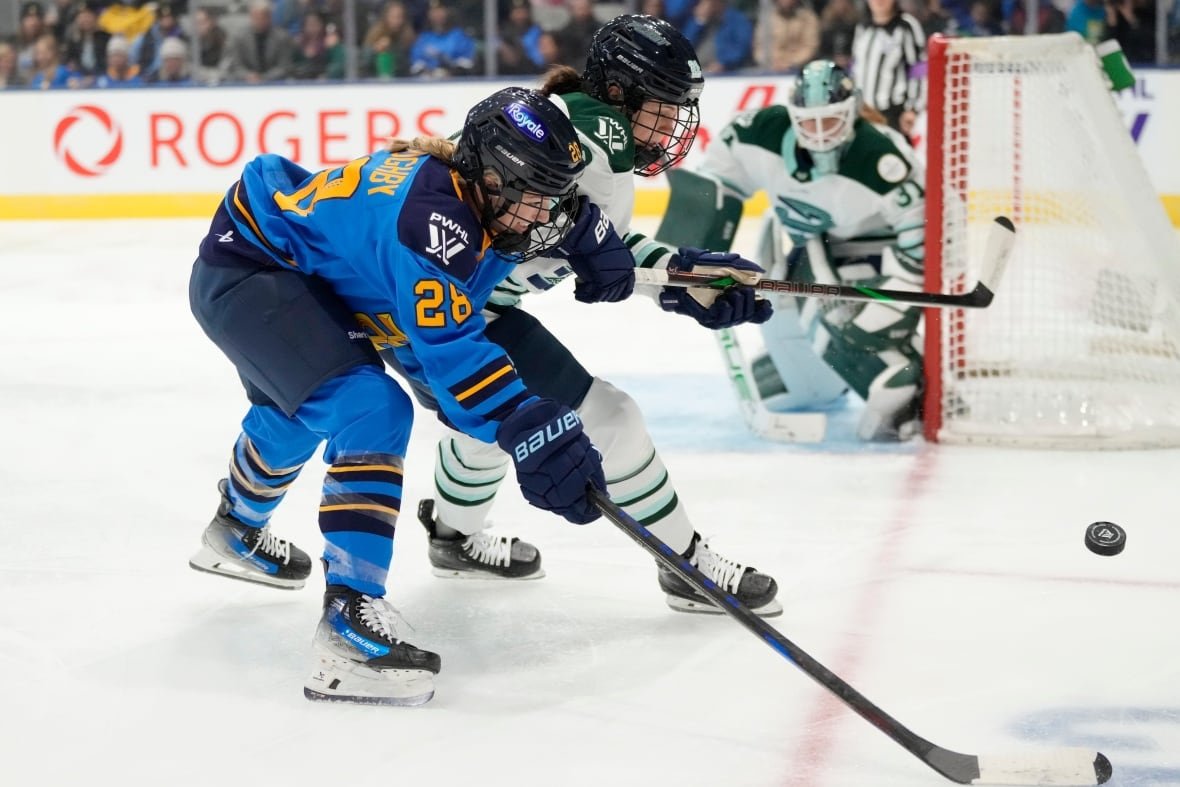 Two women's hockey players battle for the puck.