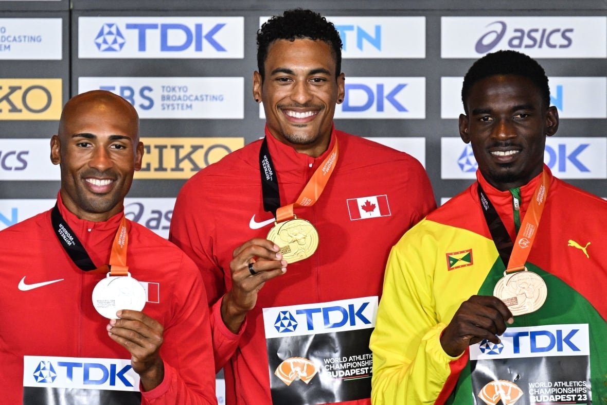 1628176260 Three men smile and pose for photos while each holding a medal draped around their necks.