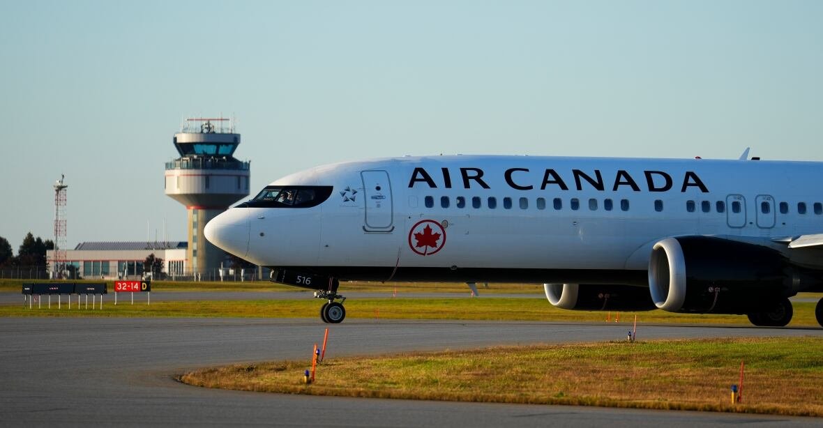 The nose of a plane is seen. The plane is white and the photo appears to have been taken outside on a runway during golden hour, when the sunlight is thick.