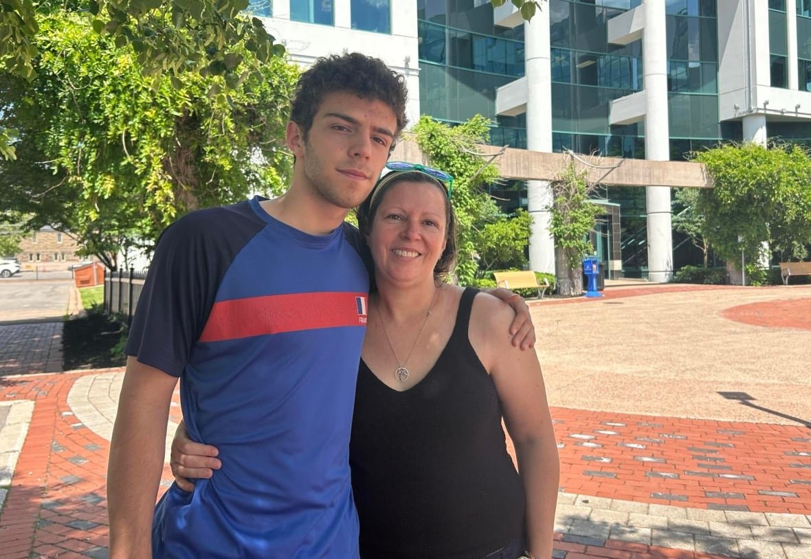 caroline-jose-and-louis-hebert-chatelain A young man and his mother stand arm in arm in front of city hall.
