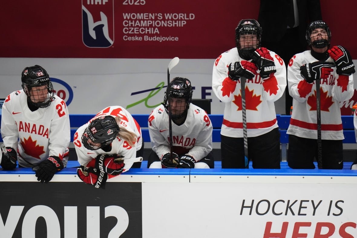 czech-republic-women-s-hockey-worlds-7 Female ice hockey players representing Canada stand dejected on their team's bench.