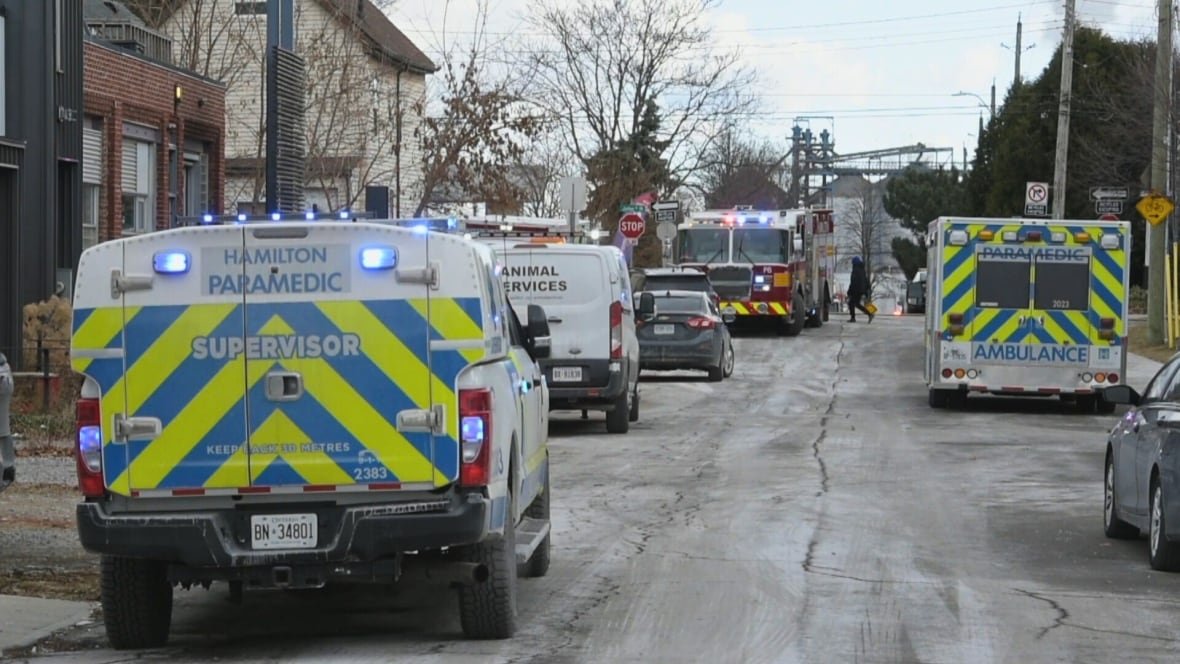 hamilton-apartment-fire-scene-jan-26-2025 A street with several ambulances and a fire truck parked on it.