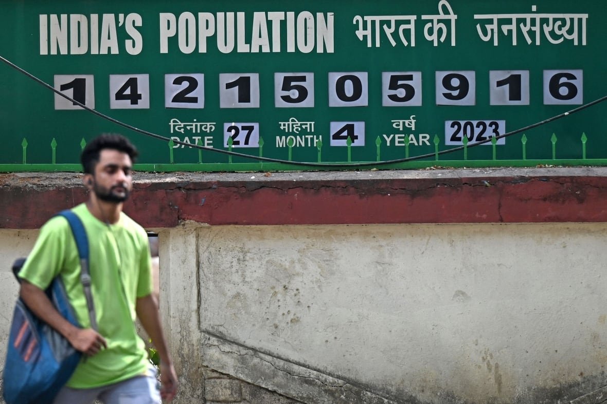 india-population-clock A man walks past a population clock.