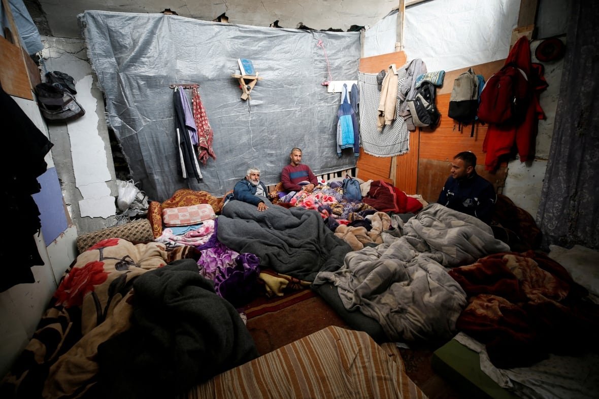 israel-palestinians-gaza-ceasefire-trump People sit in a make-shift tent home.