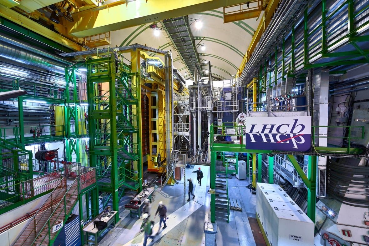 physics-muon-cern A large colourful room with lots of equipment and people wearing hard hats walking below.