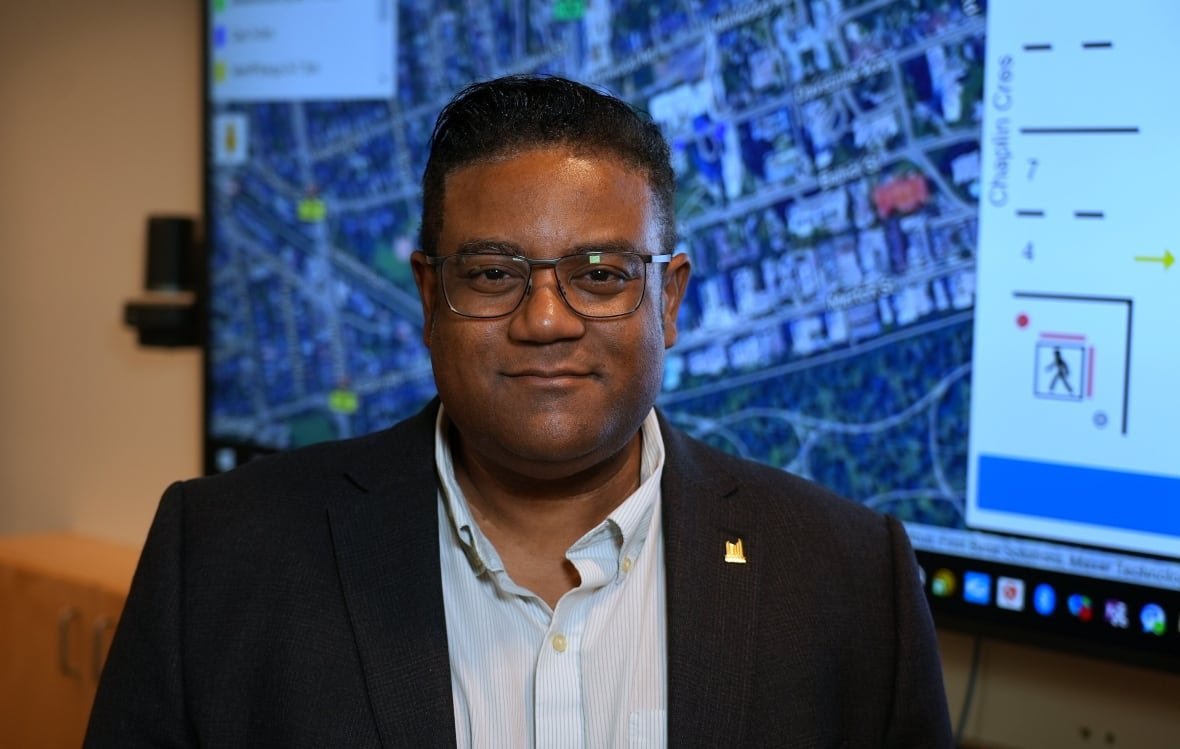 roger-browne-director-of-traffic-management-city-of-toronto Man in suit standing in front of screen.