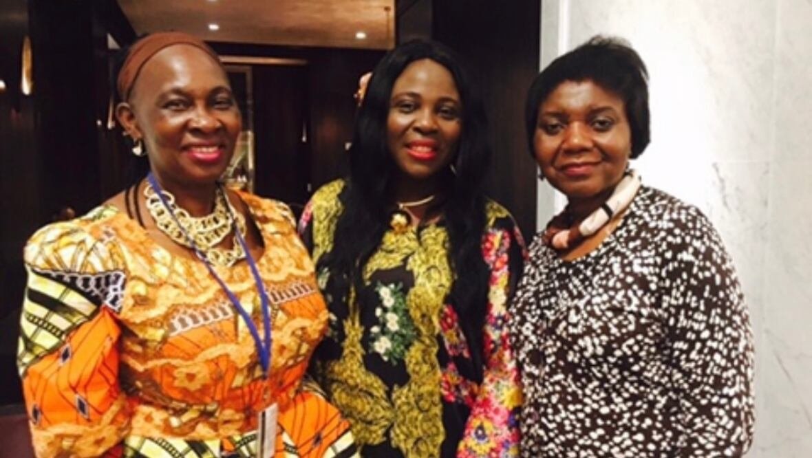 tawembi-at-un Three women in pattened dresses smile for a photo