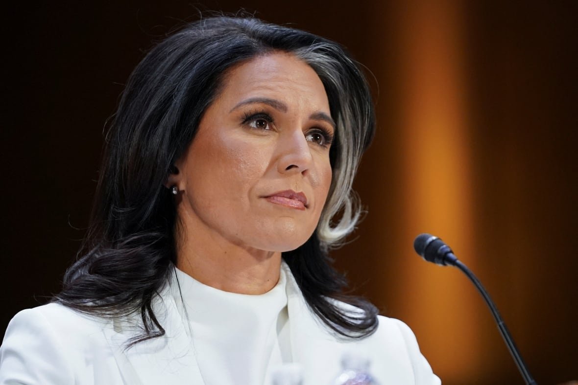 usa-trump-gabbard A woman sits in front of a microphone.