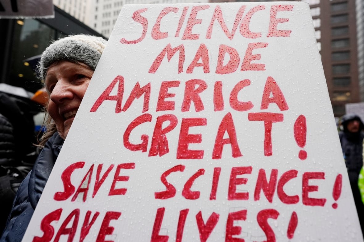 A woman holds a sign at a protest.