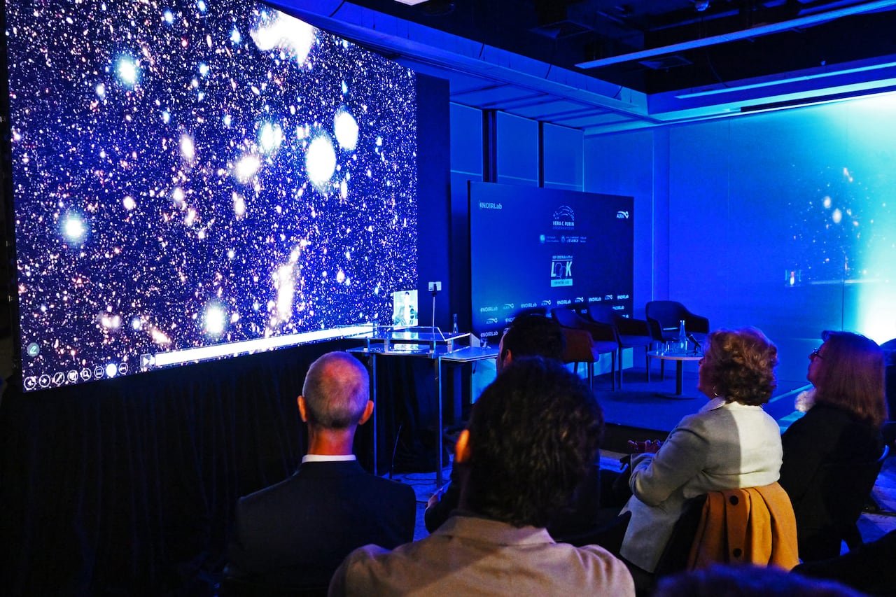 people in a conference room view images of outer space