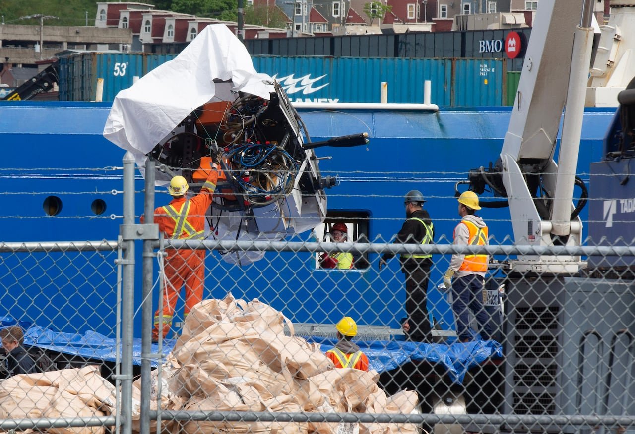Workers removing wreckage from another vessel