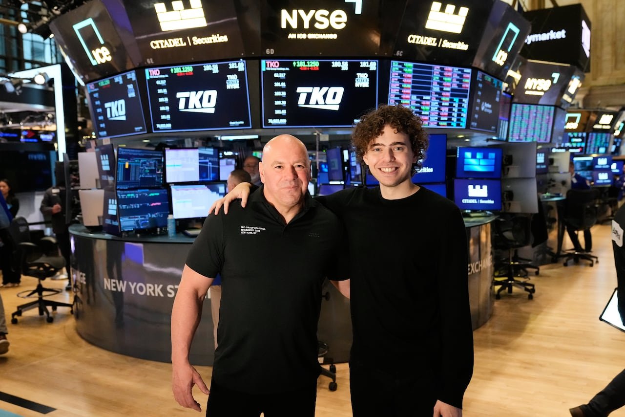 default-376 two men with their arms around each other pose for a photo on the floor of the New York Stock Exchange