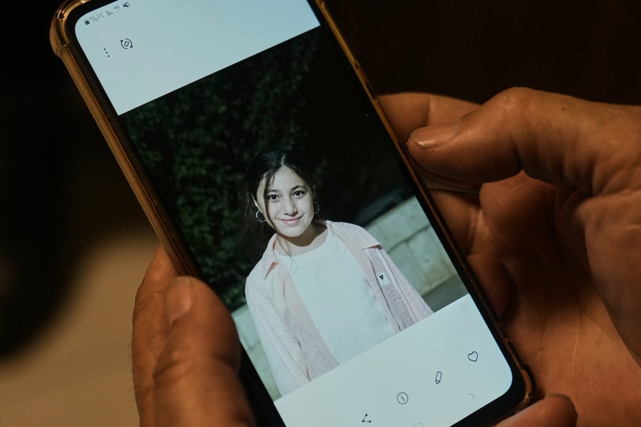 A picture of a girl is seen on a phone that someone is holding.